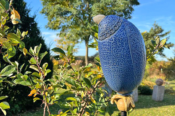 blauer Keramikvogel im Garten